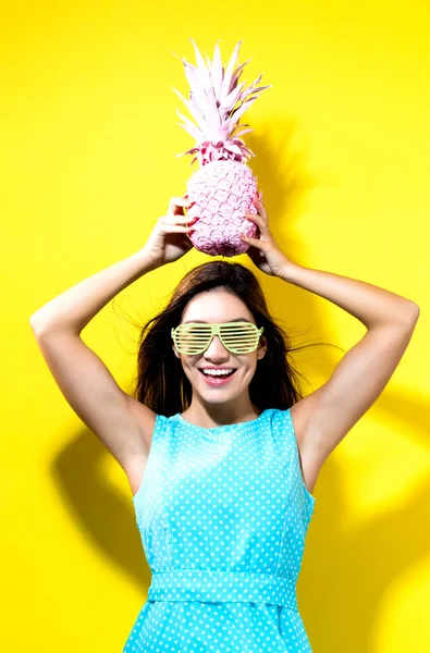 Glückliche junge Frau in der Hand einer Ananas — Stockfoto