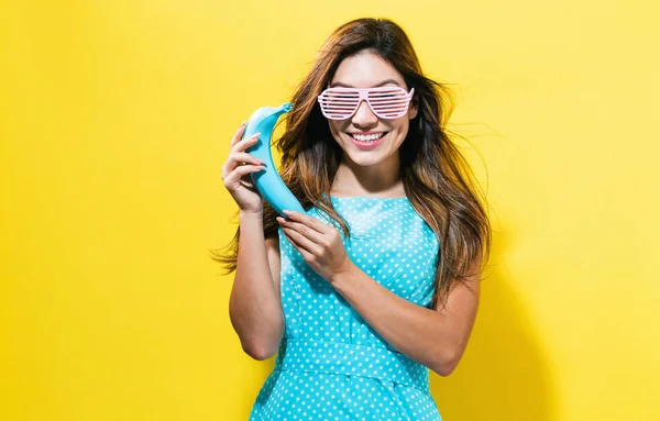 Щаслива молода жінка тримає кольоровий банан — стокове фото