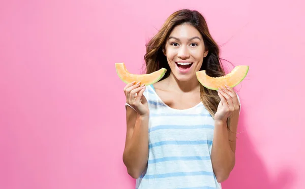 Joyeux jeune femme tenant des tranches de cantaloup — Photo