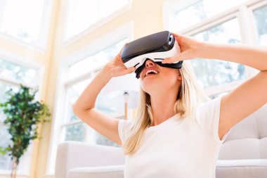 Sanal gerçeklik kulaklığı kullanan genç bir kadın.