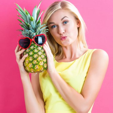 Bir ananas tutan mutlu genç kadın
