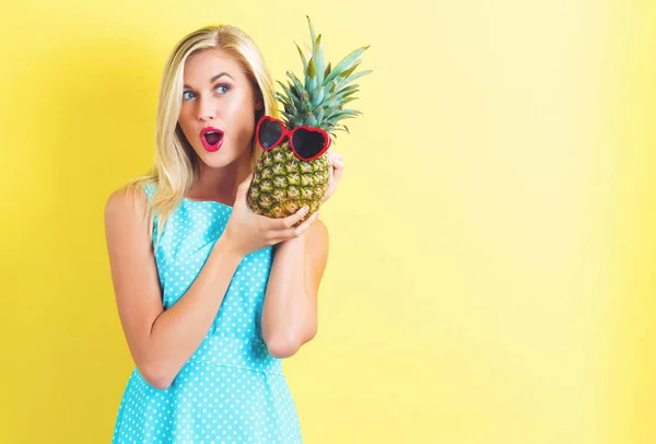 Bir ananas tutan mutlu genç kadın — Stok fotoğraf