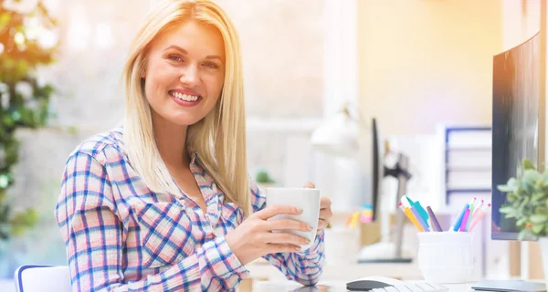 Giovane donna che beve caffè in un ufficio — Foto Stock