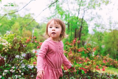 Dışında oynarken mutlu yürümeye başlayan çocuk kız