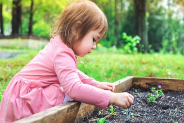 Dışında oynarken mutlu yürümeye başlayan çocuk kız