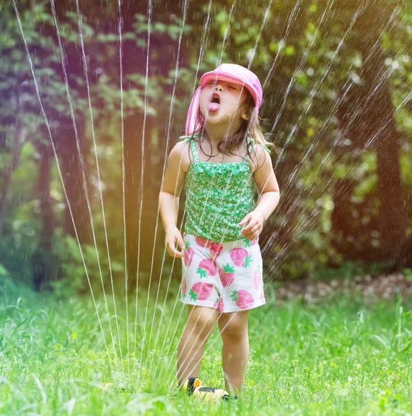 Happy toddler girl playing in a sprinkler — Stock Photo, Image