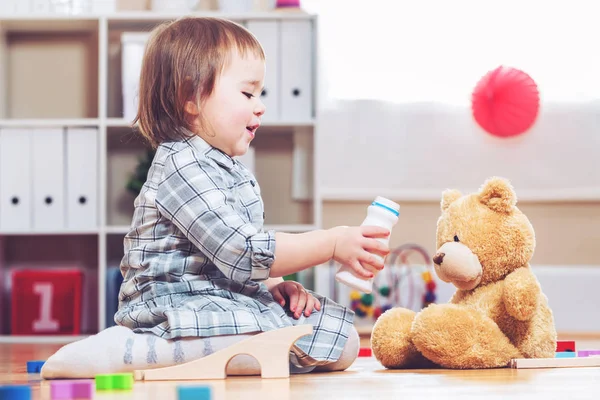 Menina criança feliz brincando com seu ursinho de pelúcia — Fotografia de Stock