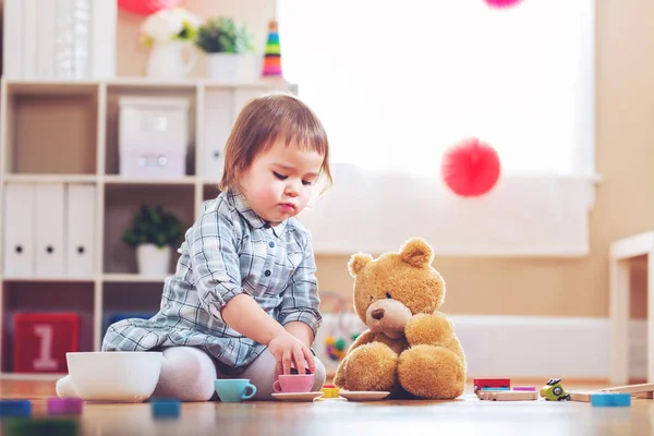 Onun oyuncak ayı ile oynarken mutlu yürümeye başlayan çocuk kız — Stok fotoğraf