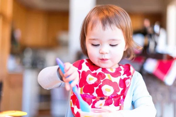 Toddler girl eating food with her spoon — Stock Photo, Image