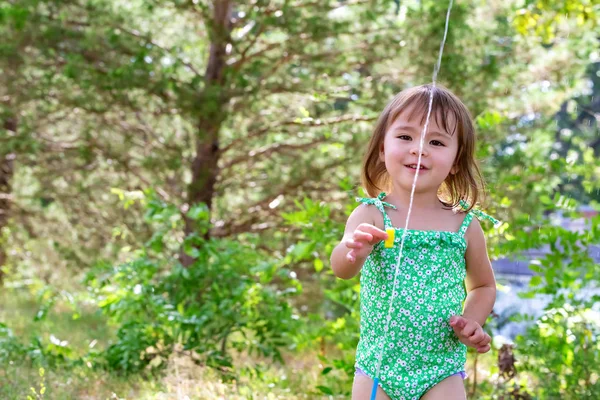 Ευχαρίστως toddler κορίτσι παίζει με ψεκαστήρα — Φωτογραφία Αρχείου