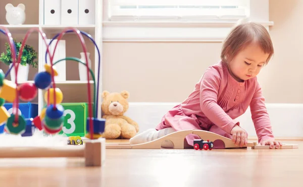 Glücklich Kleinkind Mädchen spielt mit Spielzeug Stockbild