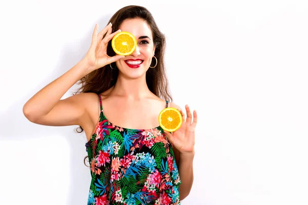 Feliz joven mujer sosteniendo naranjas mitades —  Fotos de Stock