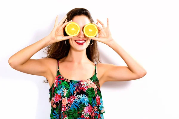 Feliz joven mujer sosteniendo naranjas mitades — Foto de Stock