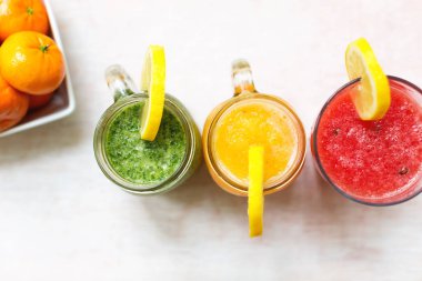 Beyaz ahşap zemin üzerinde üç smoothies