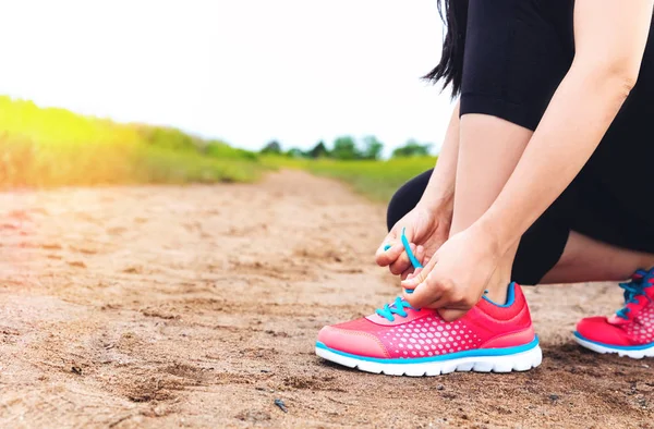 Mujer corredora atando su zapato de correr —  Fotos de Stock