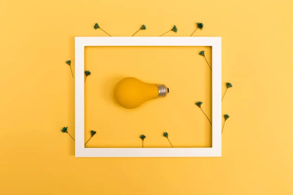Gele geschilderde gloeilamp op een levendige achtergrond — Stockfoto