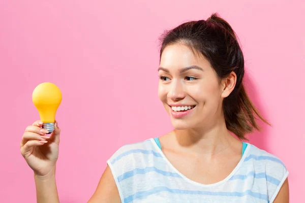 Giovane donna che tiene una lampadina — Foto Stock