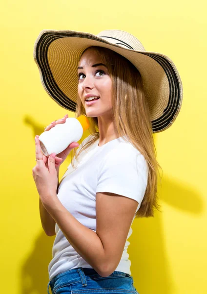 Genç kadın bir şişe güneş kremi — Stok fotoğraf