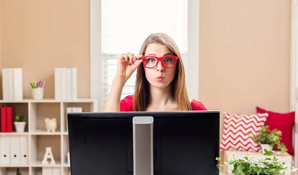 Jonge vrouw zit aan haar bureau — Stockfoto