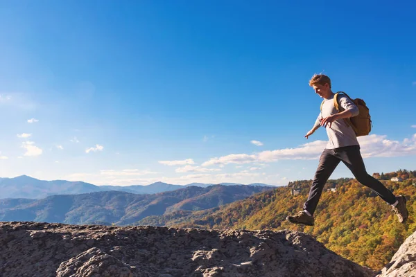 Ο άνθρωπος άλματα πάνω από το χάσμα στην ορεινή πεζοπορία — Φωτογραφία Αρχείου