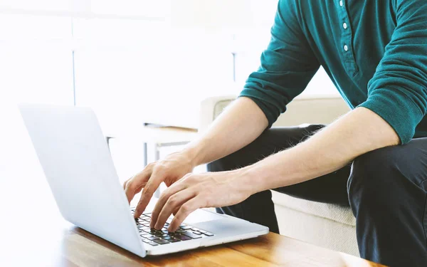 Uomo su un computer portatile in camera luminosa — Foto Stock