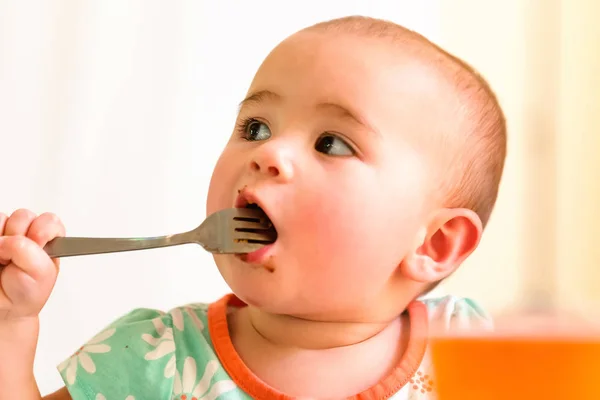 Toddler girl eating food with a fork — Stock Photo, Image