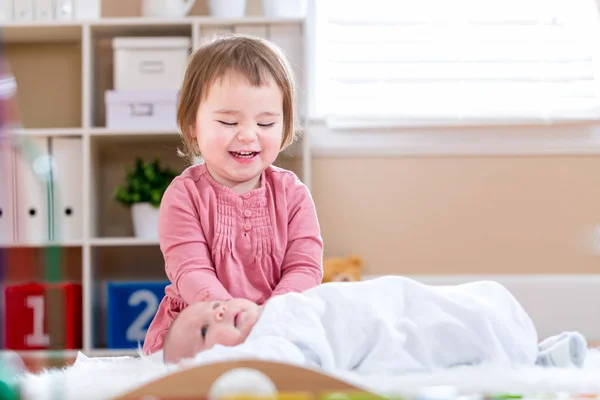 Mutlu bebek kız bebek kardeşi ile oynamaktan — Stok fotoğraf