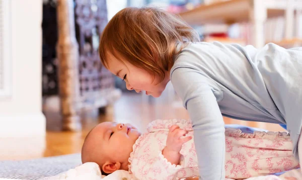 Niña jugando con su hermana recién nacida — Foto de Stock