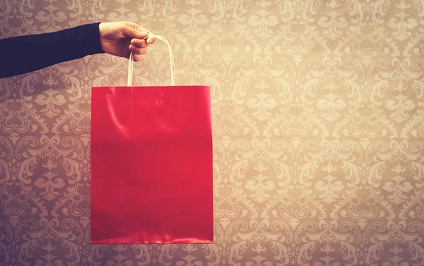 Mulher segurando um saco de compras vermelho — Fotografia de Stock