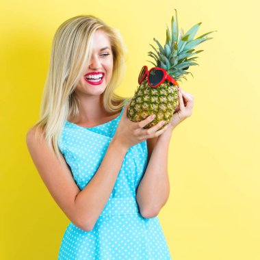 Bir ananas tutan mutlu genç kadın