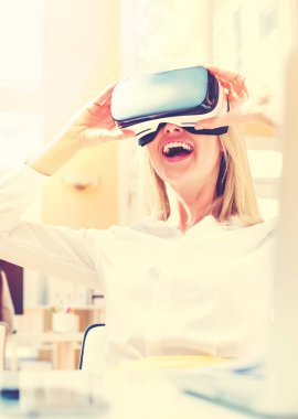 Sanal gerçeklik kulaklığı kullanan genç bir kadın.