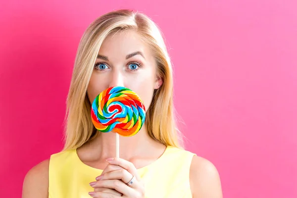 Mujer joven sosteniendo una piruleta — Foto de Stock