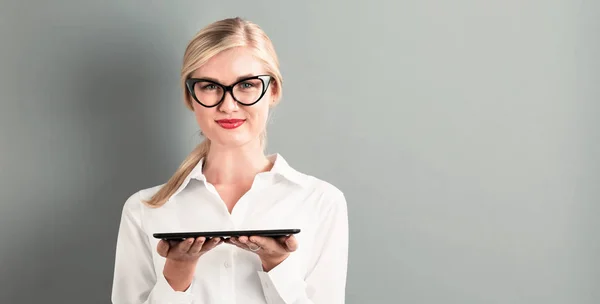 Jonge vrouw met behulp van haar tabel — Stockfoto