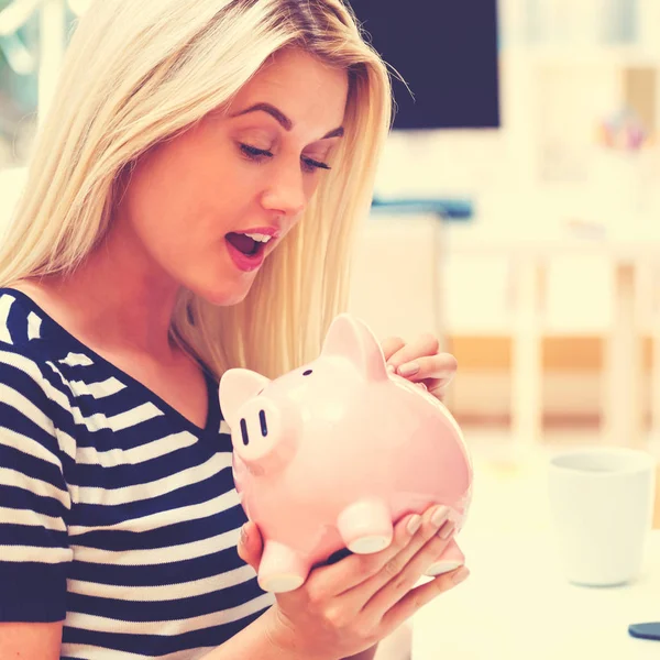 Jonge vrouw met een piggy bank — Stockfoto