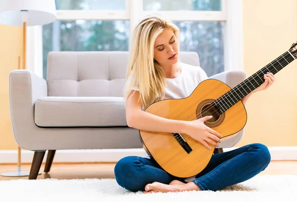 Gitar çalan genç bir kadın.