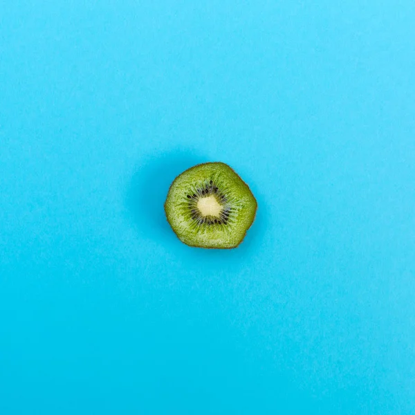 Slice of kiwi on a blue background — Stock Photo, Image