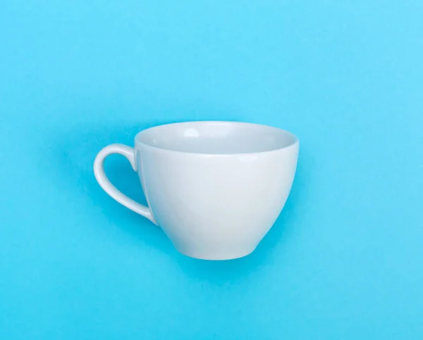 White coffee mug on blue