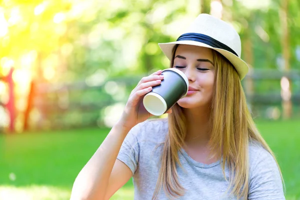 Ung kvinna dricker kaffe utanför — Stockfoto