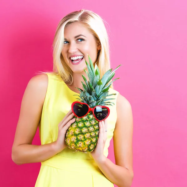 Glad ung kvinna håller en ananas — Stockfoto