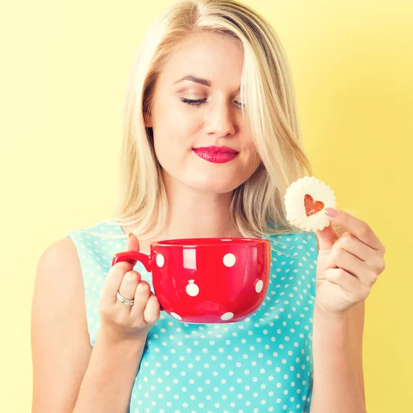 Gelukkig jonge vrouw met cookie en koffie — Stockfoto