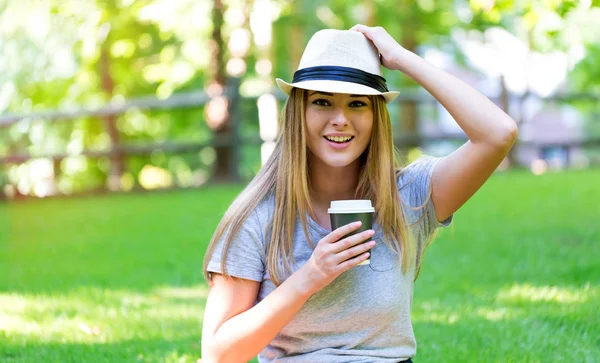 Ung kvinna dricker kaffe utanför — Stockfoto