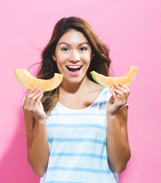 Joyeux jeune femme tenant des tranches de cantaloup — Photo