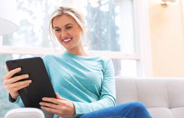 Молода жінка використовує свій планшетний комп'ютер — стокове фото