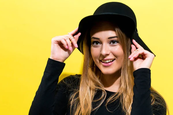 Mujer joven y feliz usando un sombrero — Foto de Stock