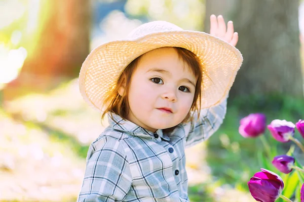Kleinkind spielt draußen mit Tulpen — Stockfoto