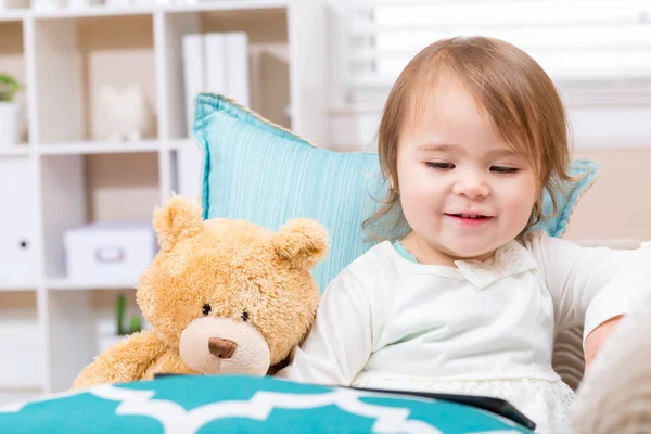 Feliz niña pequeña sentada con su osito de peluche — Foto de Stock