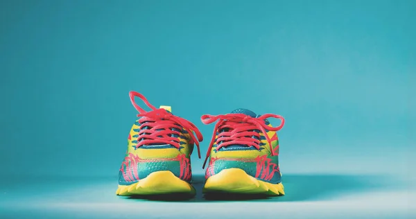 Zapatillas de running coloridas sobre un fondo azul —  Fotos de Stock