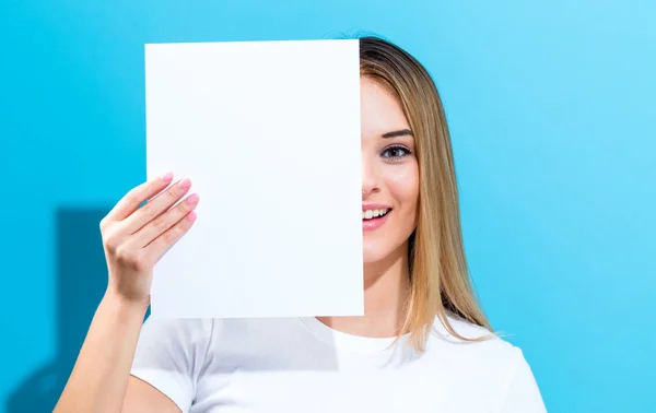 Mujer sosteniendo una hoja de papel en blanco — Foto de Stock