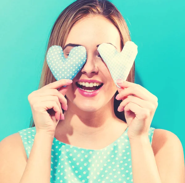 Jonge vrouw met hart kussens — Stockfoto