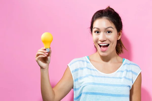 Junge Frau mit Glühbirne — Stockfoto